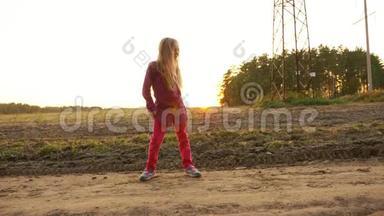 年轻的白种人女孩在户外跳舞唱歌。 在田野的田园风光中漫步秋日。 手持
